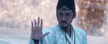 Movie still from “The Yin-Yang Master: Dream of Eternity” (2020), directed by Jingming Guo – A man in a black hat and a white robe; Close Up shot, Over the shoulder angle
