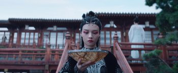 Movie still from “The Yin-Yang Master: Dream of Eternity” (2020), directed by Jingming Guo – A woman holding a bowl in front of her face; Close Up shot, Low angle