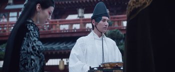 Movie still from “The Yin-Yang Master: Dream of Eternity” (2020), directed by Jingming Guo – A man wearing a white outfit and a black hat; Close Up shot, Over the shoulder angle