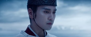Movie still from “The Yin-Yang Master: Dream of Eternity” (2020), directed by Jingming Guo – A young man with a hat on looking into the distance; Close Up shot, Low angle