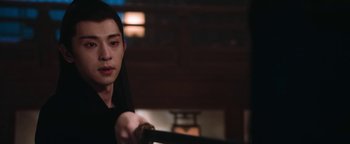 Movie still from “The Yin-Yang Master: Dream of Eternity” (2020), directed by Jingming Guo – A man holding a sword in a dark room; Close Up shot, Over the shoulder angle