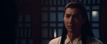 Movie still from “The Yin-Yang Master: Dream of Eternity” (2020), directed by Jingming Guo – A man in a white shirt is looking at the camera; Close Up shot, Over the shoulder angle