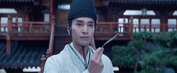 Movie still from “The Yin-Yang Master: Dream of Eternity” (2020), directed by Jingming Guo – A man holding a pair of scissors in his hand; Close Up shot, Low angle