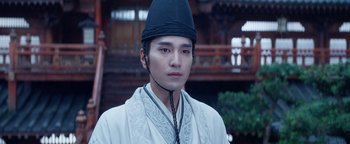 Movie still from “The Yin-Yang Master: Dream of Eternity” (2020), directed by Jingming Guo – A man wearing a black hat and a white robe; Close Up shot, Low angle