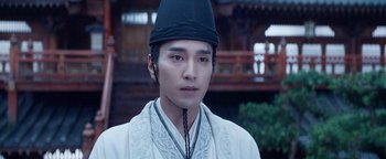 Movie still from “The Yin-Yang Master: Dream of Eternity” (2020), directed by Jingming Guo – A man wearing a black hat and a white shirt; Close Up shot, Over the shoulder angle