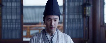 Movie still from “The Yin-Yang Master: Dream of Eternity” (2020), directed by Jingming Guo – A man wearing a black hat and a white robe; Close Up shot, Low angle