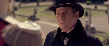 Movie still from “The Young Victoria” (2009), directed by Jean-Marc Vallée – An older man in a top hat and a black suit; Close Up shot, Over the shoulder angle