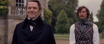 Movie still from “The Young Victoria” (2009), directed by Jean-Marc Vallée – A man in a suit standing next to another man in a white shirt; Medium shot, Over the shoulder angle