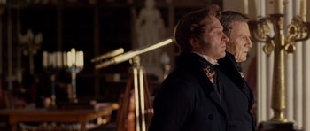 Movie still from “The Young Victoria” (2009), directed by Jean-Marc Vallée – A man standing in front of a telescope in a room; Medium shot, Over the shoulder angle