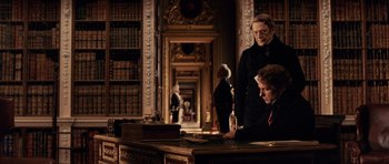Movie still from “The Young Victoria” (2009), directed by Jean-Marc Vallée – Two men are sitting at a desk in a library; Medium shot, Over the shoulder angle