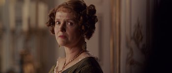 Movie still from “The Young Victoria” (2009), directed by Jean-Marc Vallée – An older woman wearing a green dress and a gold necklace; Close Up shot, Low angle