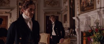 Movie still from “The Young Victoria” (2009), directed by Jean-Marc Vallée – Two men in suits standing next to each other in a room; Medium shot, Over the shoulder angle