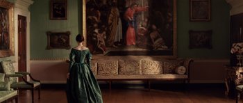 Movie still from “The Young Victoria” (2009), directed by Jean-Marc Vallée – A woman in a green dress standing in front of a painting; Wide shot, Over the shoulder angle