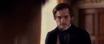 Movie still from “The Young Victoria” (2009), directed by Jean-Marc Vallée – A man with a beard and mustache wearing a suit and tie; Close Up shot, Over the shoulder angle