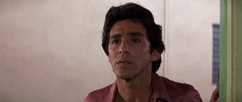 Movie still from “Scarface” (1983), directed by Brian De Palma – A person wearing a pink shirt; Close Up shot, Low angle