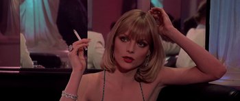 Movie still from “Scarface” (1983), directed by Brian De Palma – A woman with a cigarette in her mouth; Close Up shot, Over the shoulder angle
