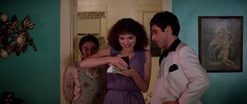 Movie still from “Scarface” (1983), directed by Brian De Palma – A group of people standing in a living room; Medium shot, Over the shoulder angle