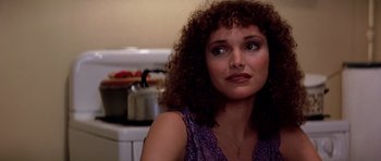 Movie still from “Scarface” (1983), directed by Brian De Palma – A person sitting in a room; Close Up shot, Over the shoulder angle