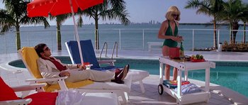 Movie still from “Scarface” (1983), directed by Brian De Palma – Two women in bikinis are standing by the pool; Wide shot, Low angle