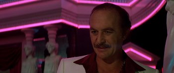 Movie still from “Scarface” (1983), directed by Brian De Palma – A person wearing a suit and tie; Close Up shot, Low angle