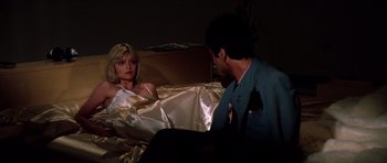 Movie still from “Scarface” (1983), directed by Brian De Palma – A man and a woman sitting on a bed in front of each other; Medium shot, Low angle