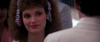 Movie still from “Scarface” (1983), directed by Brian De Palma – A person with a flower in her hair; Close Up shot, Over the shoulder angle