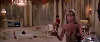 Movie still from “Scarface” (1983), directed by Brian De Palma – A man and a woman sitting in front of each other in a room; Wide shot, Over the shoulder angle