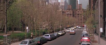 Movie still from “Scarface” (1983), directed by Brian De Palma – Cars are parked along a street in a city park; Extreme Wide shot, High angle