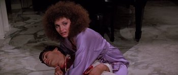 Movie still from “Scarface” (1983), directed by Brian De Palma – A woman and a man are playing a game; Medium shot, High angle