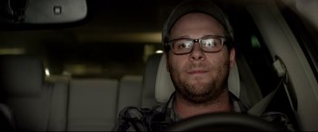 Movie still from “This Is the End” (2013), directed by Seth Rogen – A person in a car wearing glasses; Close Up shot, Over the shoulder angle