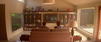 Movie still from “This Is the End” (2013), directed by Seth Rogen – Two people sitting on a couch watching television; Wide shot, Over the shoulder angle