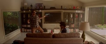 Movie still from “This Is the End” (2013), directed by Seth Rogen – Two men are playing a video game in a living room; Wide shot, Over the shoulder angle