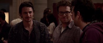 Movie still from “This Is the End” (2013), directed by Seth Rogen – Two men standing next to each other in front of a group of people; Medium shot, Over the shoulder angle