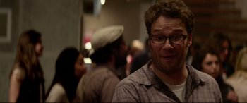 Movie still from “This Is the End” (2013), directed by Seth Rogen – A person wearing glasses and a hat; Close Up shot, Over the shoulder angle