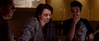 Movie still from “This Is the End” (2013), directed by Seth Rogen – A man sitting in front of another man in a room; Medium shot, Over the shoulder angle