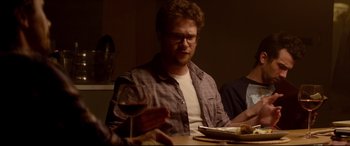 Movie still from “This Is the End” (2013), directed by Seth Rogen – A man sitting at a table with a glass of red wine; Medium shot, Over the shoulder angle