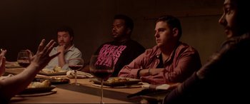 Movie still from “This Is the End” (2013), directed by Seth Rogen – A group of people sitting at a table with wine glasses; Medium shot, Over the shoulder angle