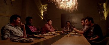 Movie still from “This Is the End” (2013), directed by Seth Rogen – A group of people sitting at a dinner table; Medium shot, High angle