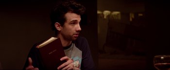 Movie still from “This Is the End” (2013), directed by Seth Rogen – A man holding a book in his hands; Close Up shot, Over the shoulder angle