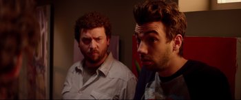 Movie still from “This Is the End” (2013), directed by Seth Rogen – Two men standing next to each other in front of a painting; Close Up shot, Over the shoulder angle