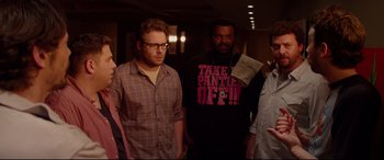 Movie still from “This Is the End” (2013), directed by Seth Rogen – A group of people standing next to each other in a room; Medium shot, Over the shoulder angle