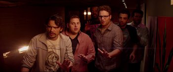 Movie still from “This Is the End” (2013), directed by Seth Rogen – A group of men standing next to each other in a room; Medium shot, High angle