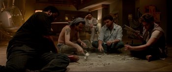 Movie still from “This Is the End” (2013), directed by Seth Rogen – A group of men sitting on the floor in a living room; Wide shot, High angle
