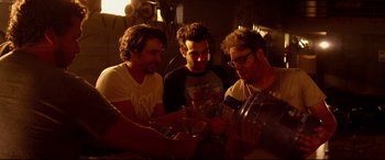 Movie still from “This Is the End” (2013), directed by Seth Rogen – A group of men sitting at a table holding wine glasses; Medium shot, High angle