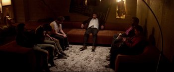 Movie still from “This Is the End” (2013), directed by Seth Rogen – A group of people sitting on a couch in a room; Wide shot, High angle
