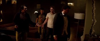 Movie still from “This Is the End” (2013), directed by Seth Rogen – A group of men standing next to each other in a dark room; Medium shot, Over the shoulder angle