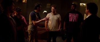 Movie still from “This Is the End” (2013), directed by Seth Rogen – Two men standing next to each other in a dark room; Medium shot, Over the shoulder angle