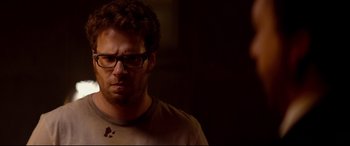 Movie still from “This Is the End” (2013), directed by Seth Rogen – A person wearing glasses and a brown shirt; Close Up shot, Over the shoulder angle