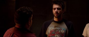 Movie still from “This Is the End” (2013), directed by Seth Rogen – A man in a black shirt is talking to another man; Medium shot, Over the shoulder angle