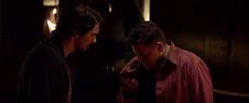 Movie still from “This Is the End” (2013), directed by Seth Rogen – A man is fixing another man's tie in a dark room; Close Up shot, Over the shoulder angle